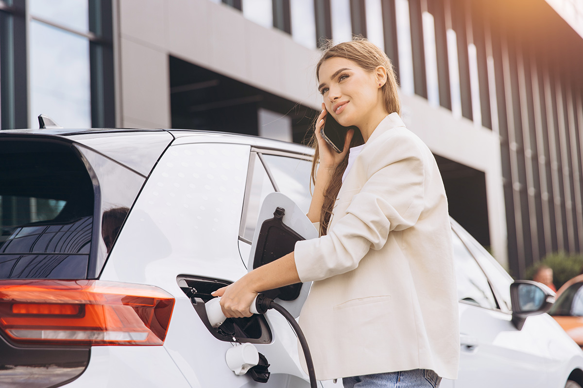 Banner einer Frau die ihr Auto bei einer schneller-strom-laden.de Tankstelle lädt